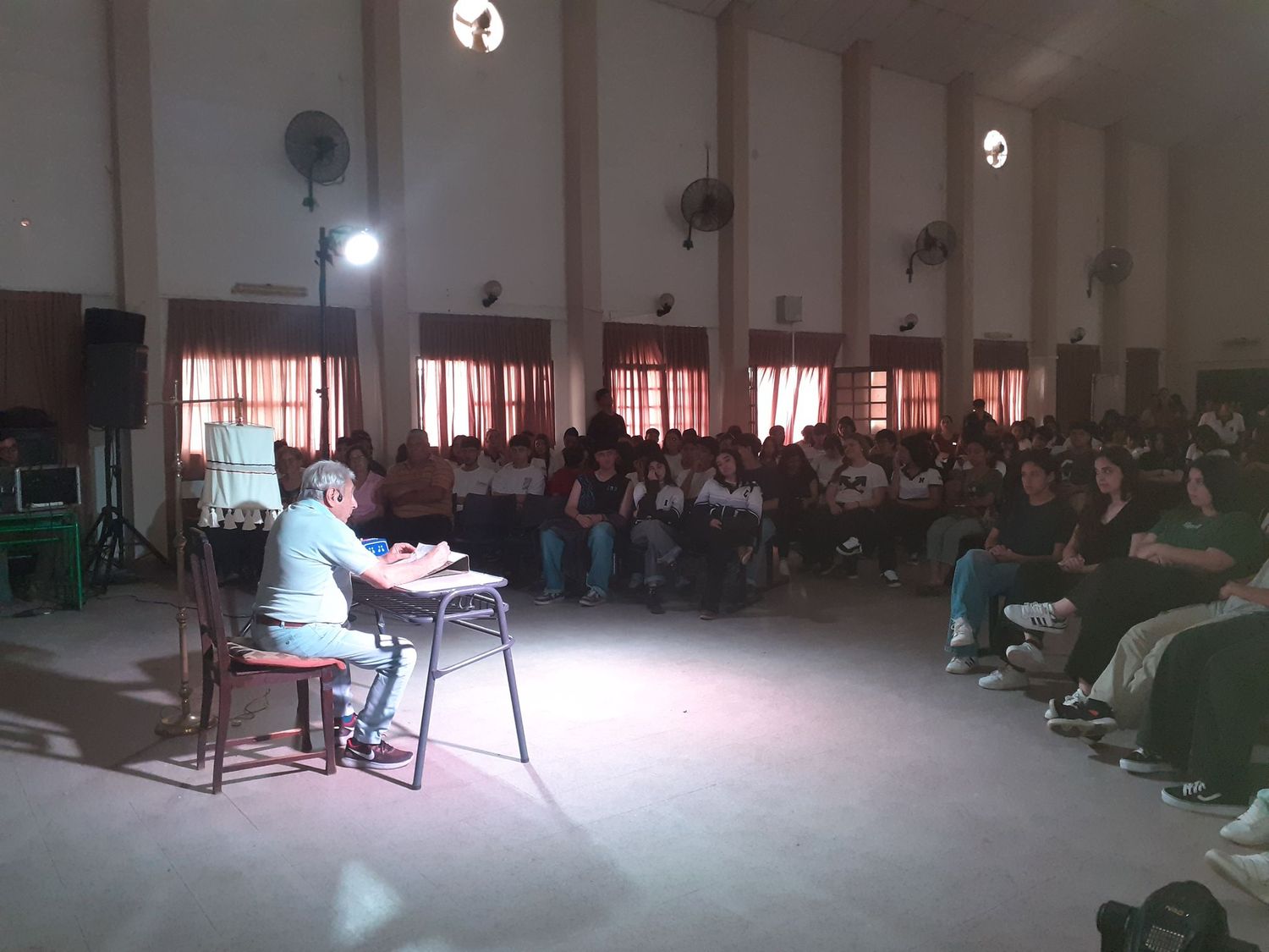 Estudiantes escuchan atentos la presentación de "Los Manecos de la Capilla".